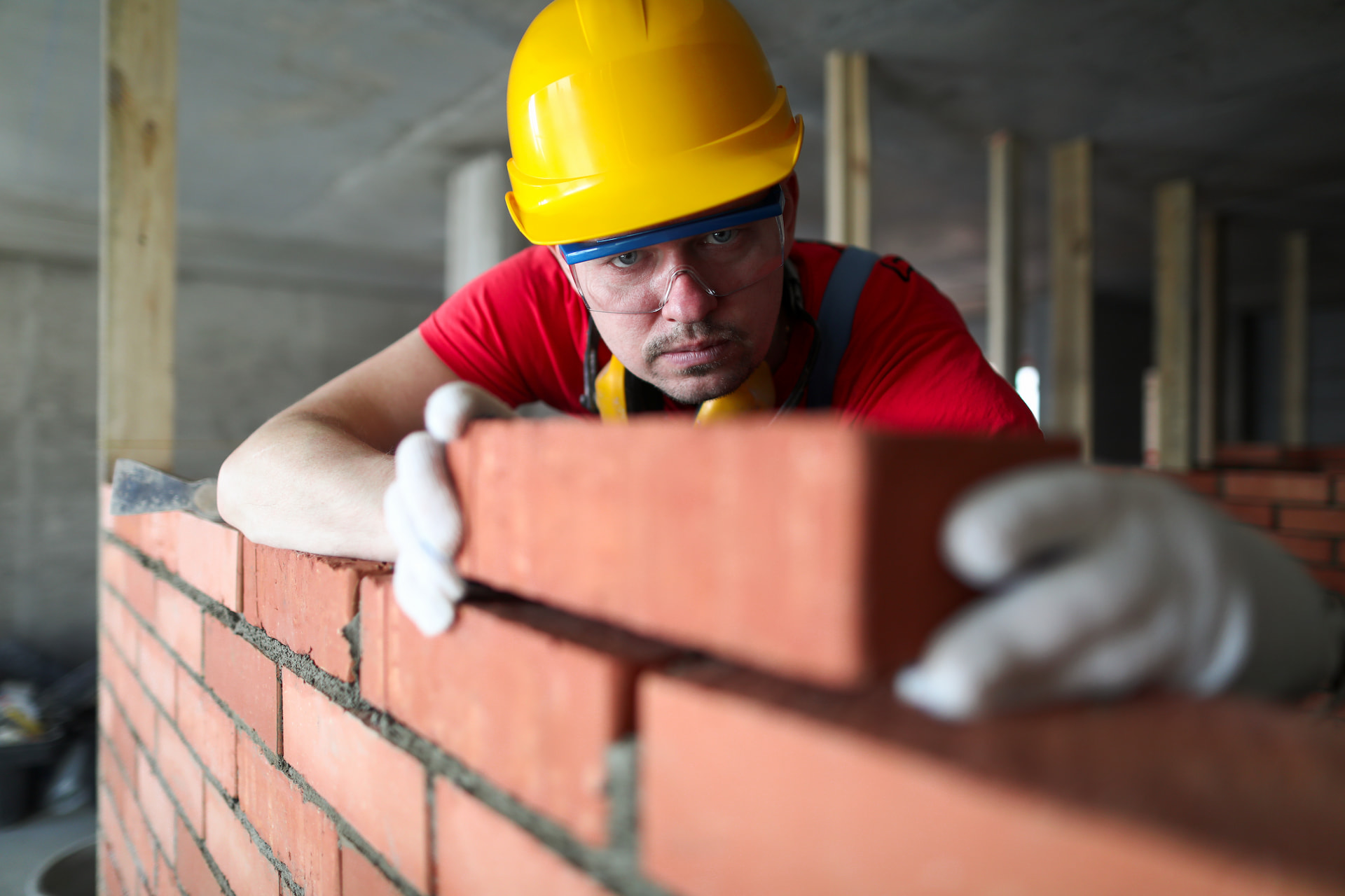 builder-carefully-puts-red-brick-masonry (1) (1)